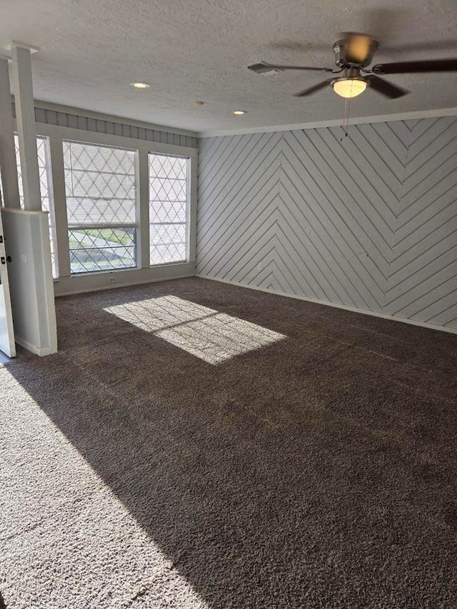 spare room with carpet, wood walls, recessed lighting, a textured ceiling, and a ceiling fan