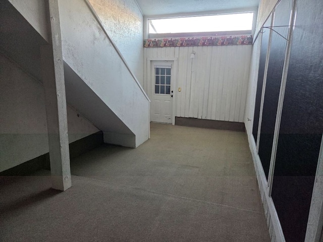 below grade area with stairs and carpet flooring