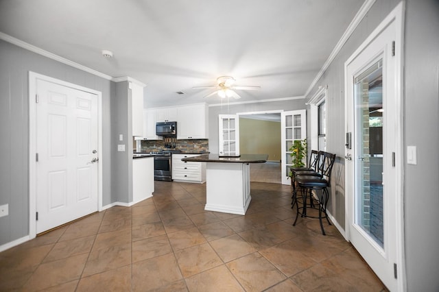 4 Pinemont Pl, Lufkin, TX 75904 - kitchen featuring black microwave, stainless steel range oven, dark countertops, crown molding, and backsplash