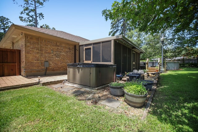 4 Pinemont Pl, Lufkin, TX 75904 - back of property with a sunroom, brick siding, a yard, and a hot tub