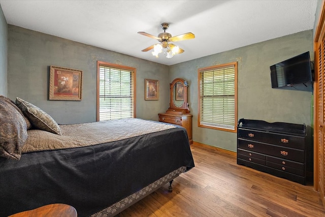 bedroom with light hardwood / wood-style floors and ceiling fan