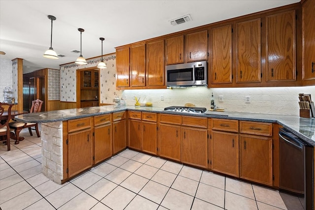 kitchen with kitchen peninsula, light tile patterned floors, hanging light fixtures, and appliances with stainless steel finishes