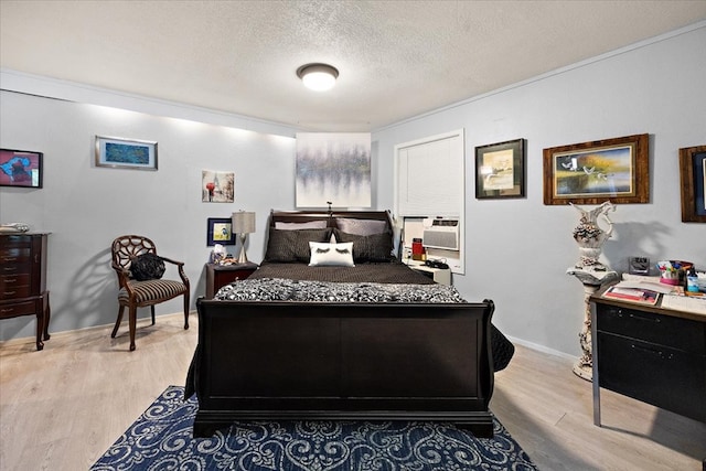 bedroom with light hardwood / wood-style flooring, cooling unit, and a textured ceiling