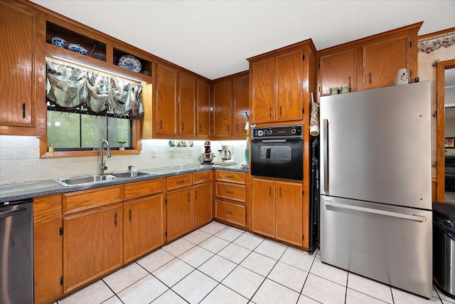 kitchen featuring decorative backsplash, light tile patterned floors, stainless steel appliances, and sink