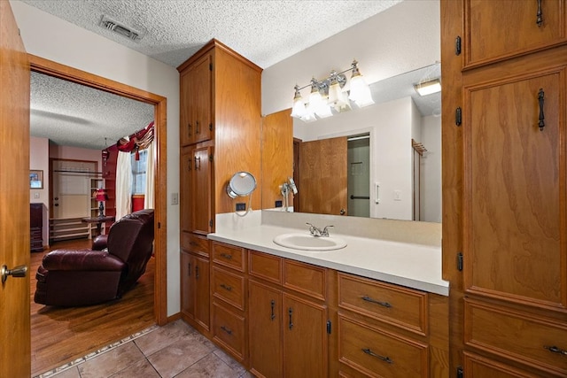 bathroom with tile patterned floors, vanity, and a textured ceiling