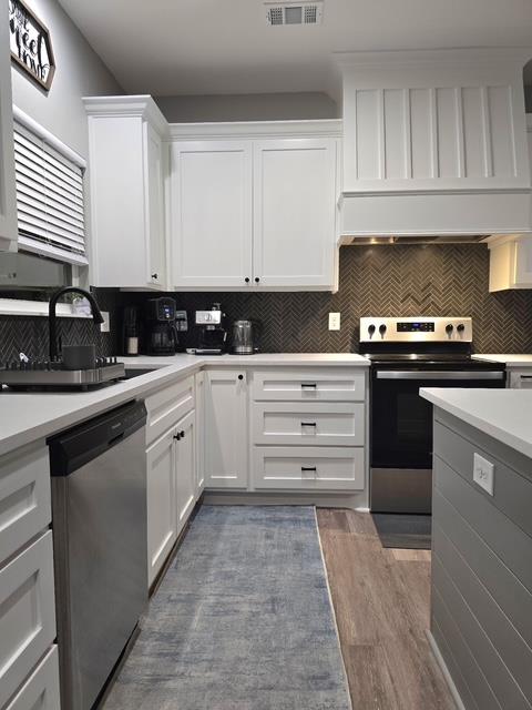 kitchen with light countertops, white cabinetry, and stainless steel appliances