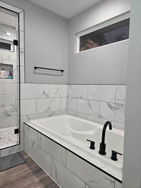 bathroom featuring a garden tub and wood finished floors