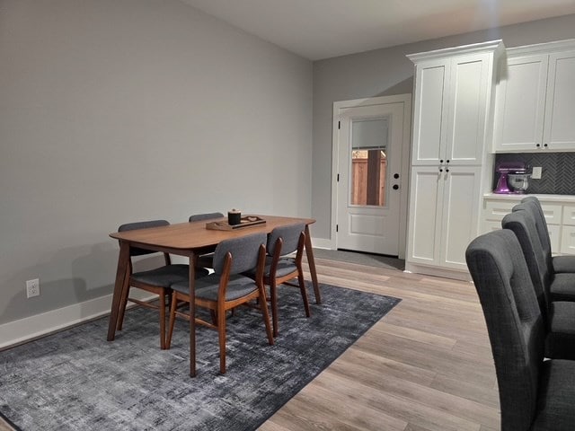 dining room featuring baseboards and light wood-type flooring