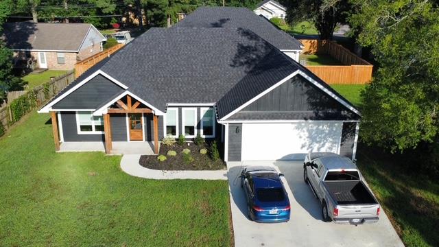 view of front of home featuring fence, an attached garage, concrete driveway, and a front lawn