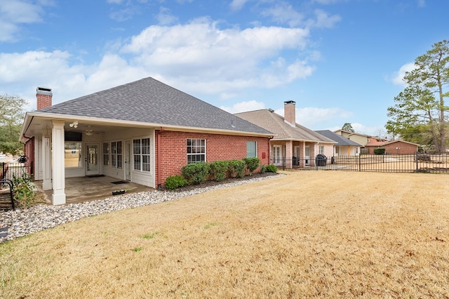 back of house featuring a lawn and a patio area