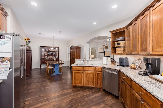 kitchen featuring pendant lighting, sink, stainless steel appliances, dark hardwood / wood-style floors, and light stone counters