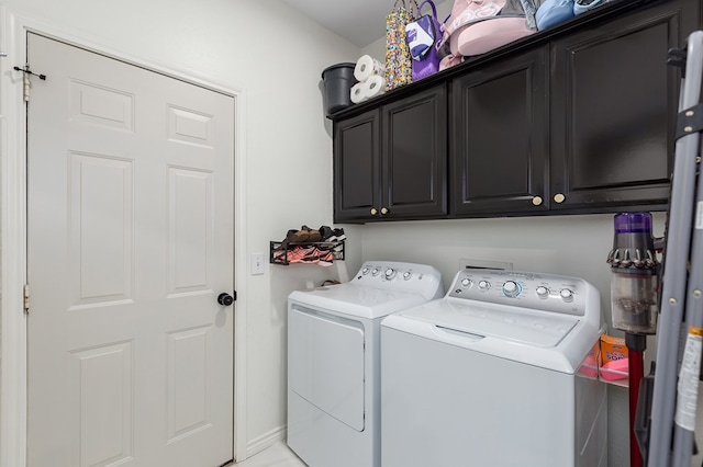 clothes washing area featuring cabinets and washer and dryer