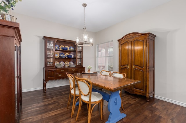 dining room with dark wood-type flooring and an inviting chandelier