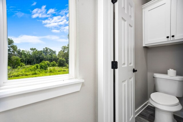 2510 Jimmie, Lufkin, TX 74904 - bathroom featuring toilet, baseboards, and wood finished floors
