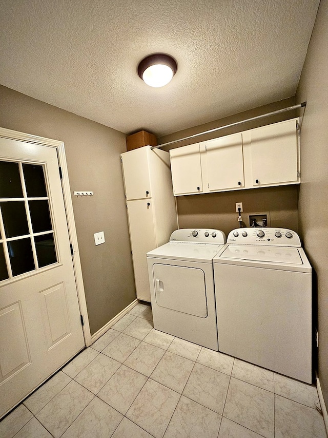 laundry area with cabinets, independent washer and dryer, a textured ceiling, and light tile patterned floors