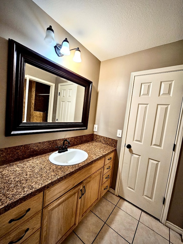 bathroom with tile patterned floors, vanity, and a textured ceiling