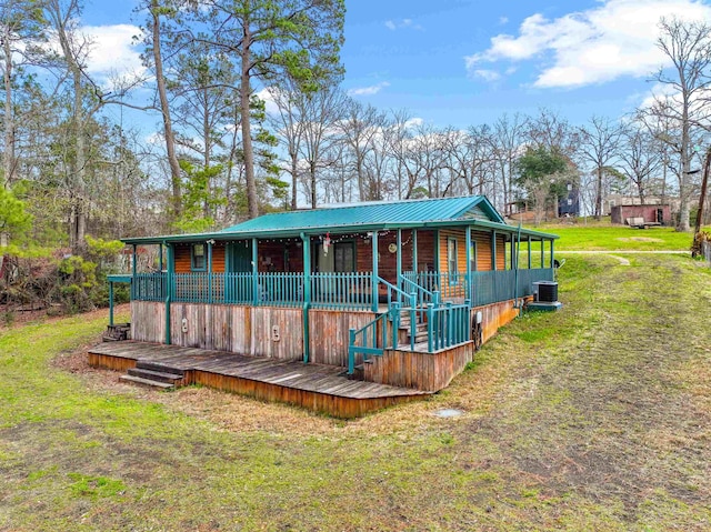 back of property with central AC unit, a porch, and a yard