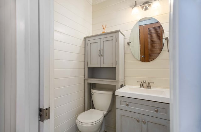 bathroom with toilet, ornamental molding, and vanity
