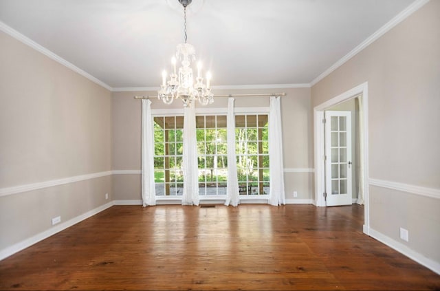 unfurnished dining area featuring baseboards, ornamental molding, a notable chandelier, and wood finished floors