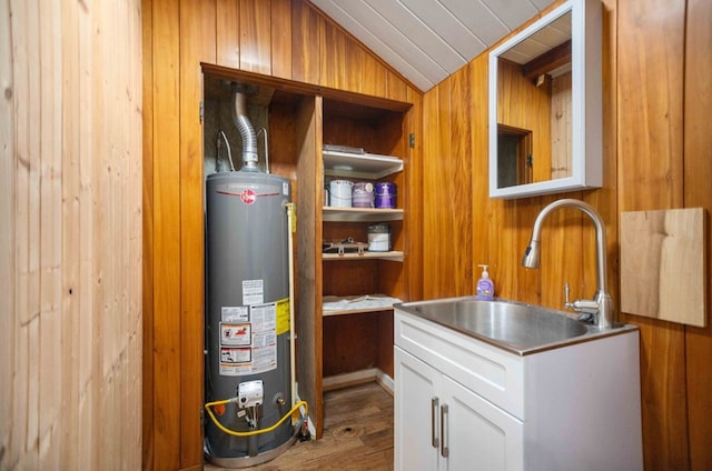 utility room with gas water heater and a sink