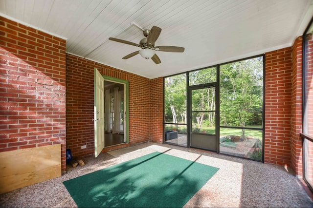 unfurnished sunroom featuring ceiling fan and a wealth of natural light