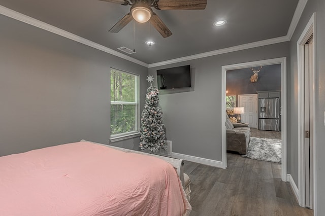 bedroom with crown molding, visible vents, stainless steel refrigerator with ice dispenser, baseboards, and wood finished floors