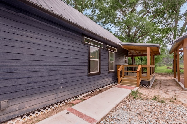 view of side of property featuring a deck and metal roof