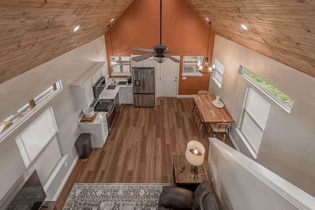 living room with a wealth of natural light, high vaulted ceiling, a ceiling fan, and wood ceiling