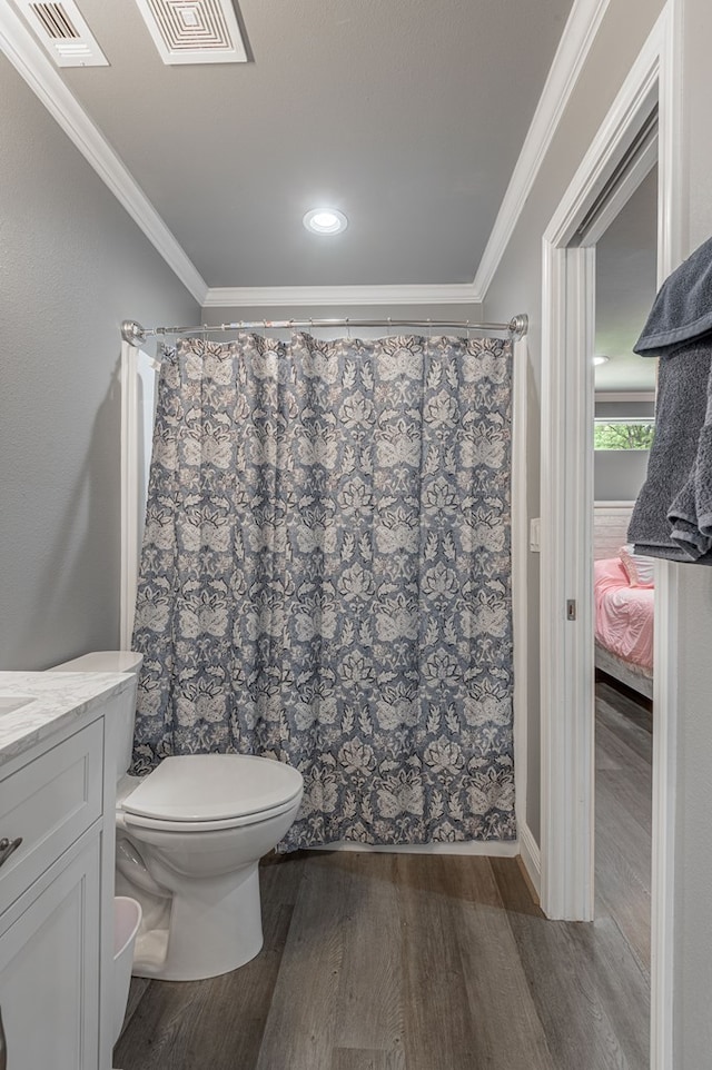 bathroom with visible vents, wood finished floors, toilet, and ornamental molding