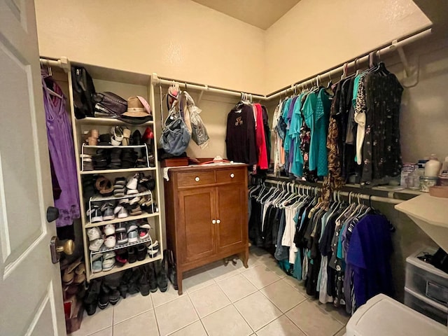 walk in closet with light tile patterned floors