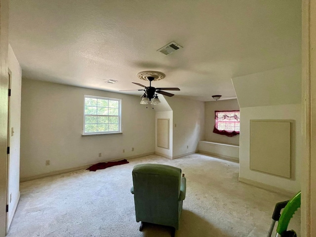 bonus room with ceiling fan, light colored carpet, and a textured ceiling