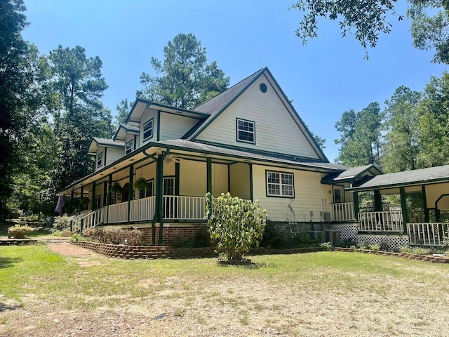 view of side of property with a porch and a lawn