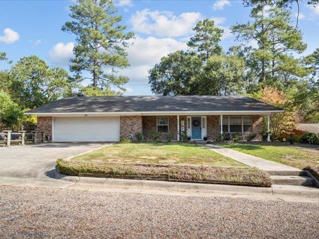 ranch-style house with a garage and a front lawn