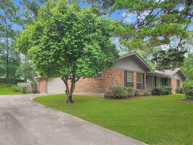 906 Richardson Dr, Jasper, TX 75951 - view of front of home featuring brick siding, driveway, board and batten siding, and a garage