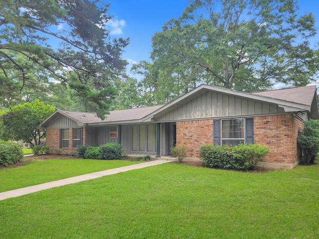 906 Richardson Dr, Jasper, TX 75951 - single story home with board and batten siding, brick siding, and a front lawn