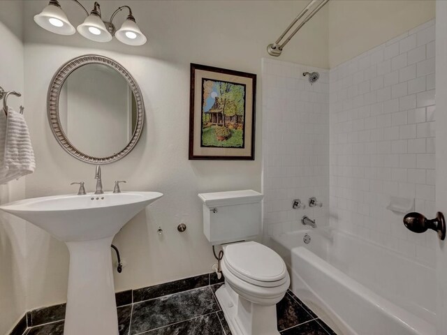 bathroom featuring tile patterned floors, toilet, and tiled shower / bath