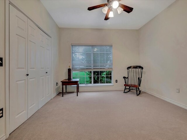 living area with ceiling fan and light colored carpet