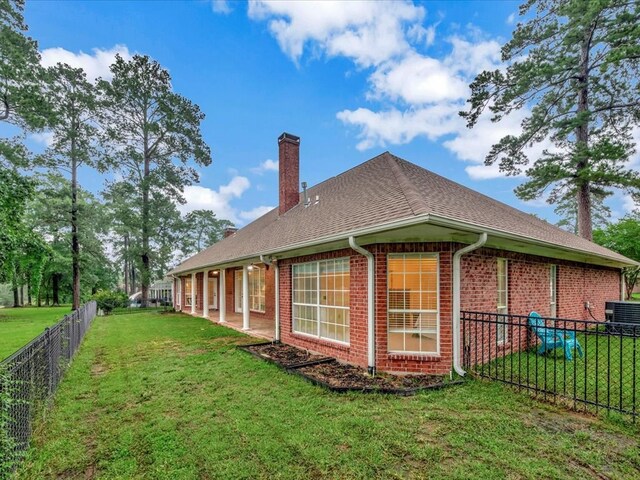 view of home's exterior with a lawn and central AC