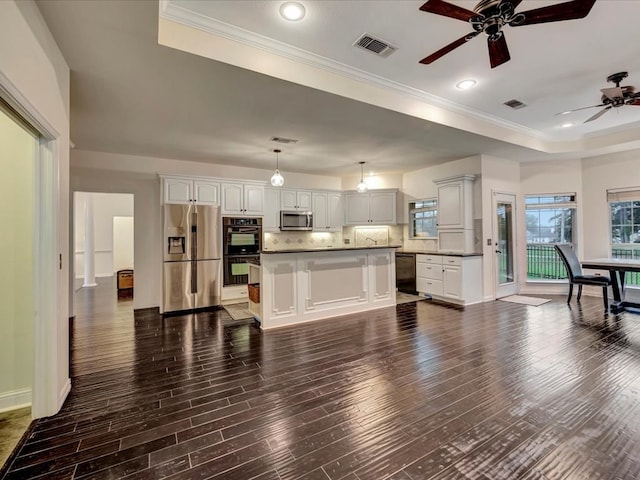 kitchen featuring pendant lighting, a kitchen island, dark wood-type flooring, and black appliances