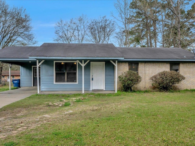 ranch-style home featuring an attached carport, a front yard, brick siding, and driveway