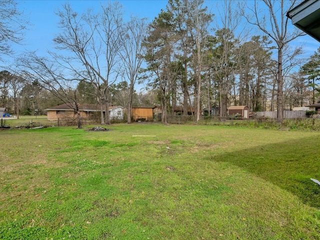 view of yard featuring an outbuilding and fence