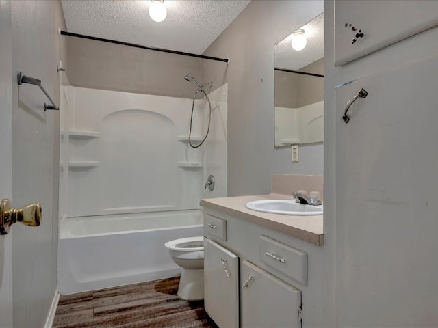 full bathroom with toilet, shower / bath combination, vanity, wood finished floors, and a textured ceiling