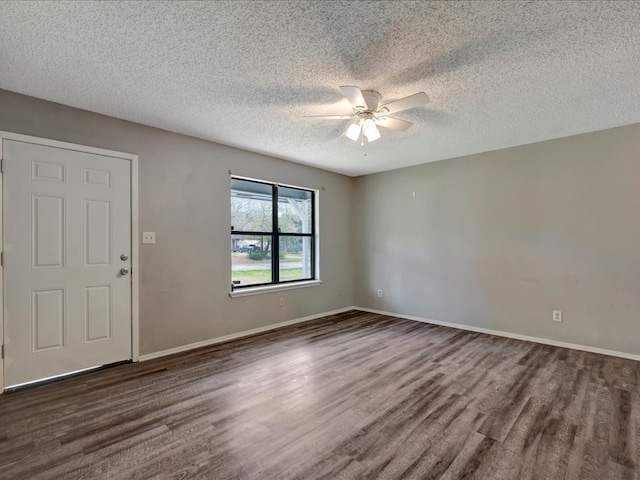 spare room with ceiling fan, baseboards, a textured ceiling, and dark wood finished floors