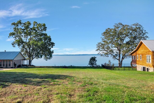 view of yard featuring a water view and central air condition unit