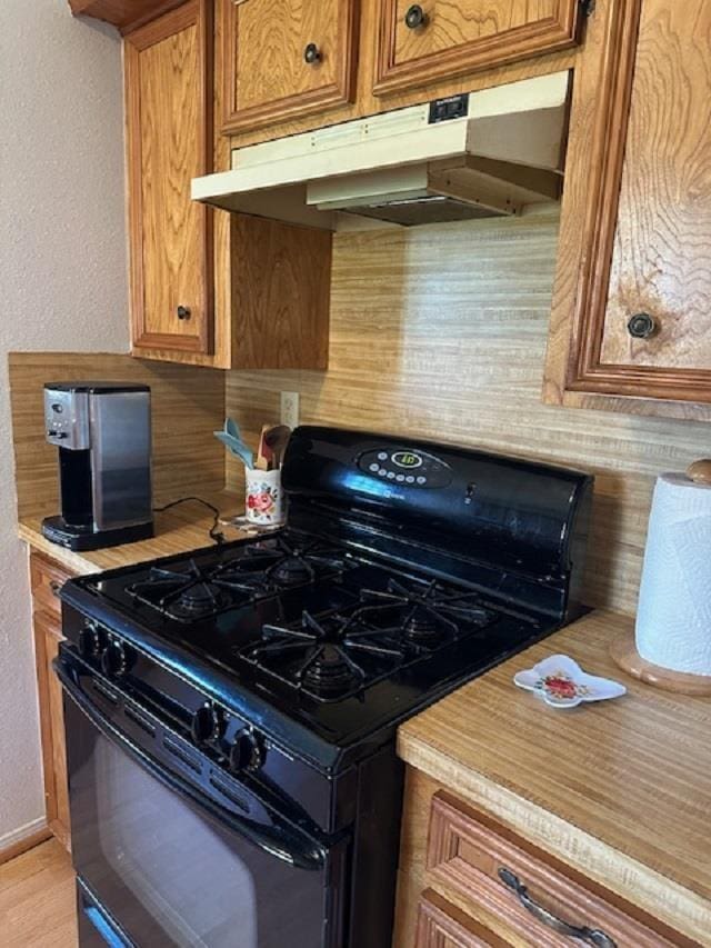 kitchen with black gas stove and backsplash