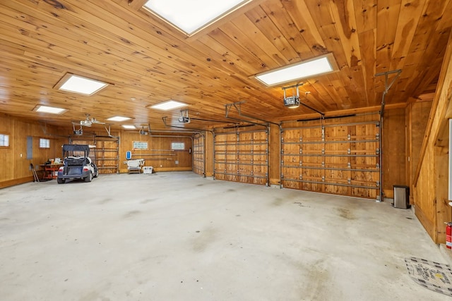 225 Mcgregor Dr, Brookeland, TX 75931 - garage with wooden ceiling, wood walls, and a garage door opener