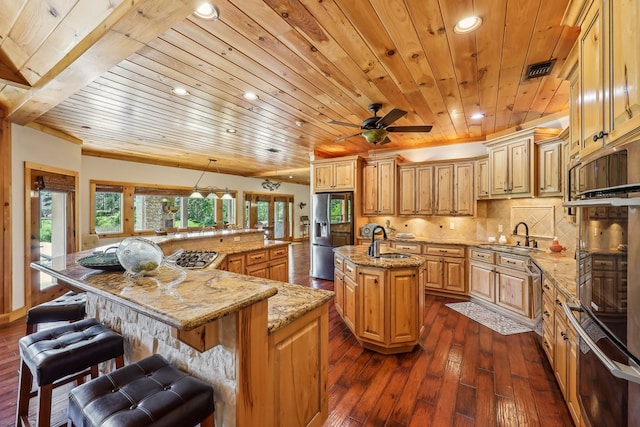 225 Mcgregor Dr, Brookeland, TX 75931 - kitchen featuring a sink, appliances with stainless steel finishes, dark wood-style flooring, a large island with sink, and wooden ceiling