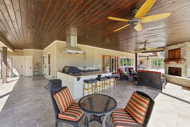 225 Mcgregor Dr, Brookeland, TX 75931 - view of patio featuring area for grilling, an outdoor bar, an outdoor stone fireplace, outdoor dining space, and ceiling fan