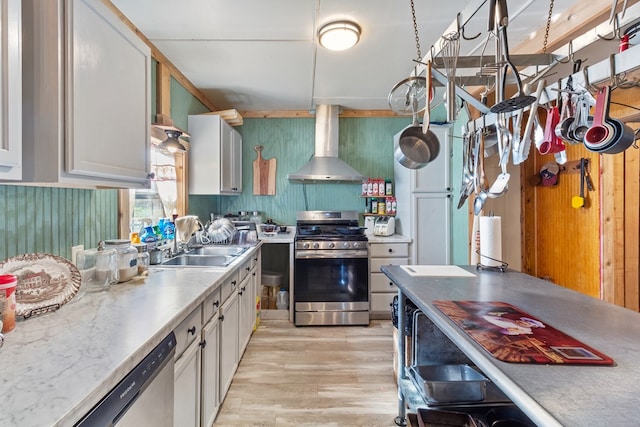 kitchen with sink, light hardwood / wood-style floors, wall chimney range hood, and appliances with stainless steel finishes