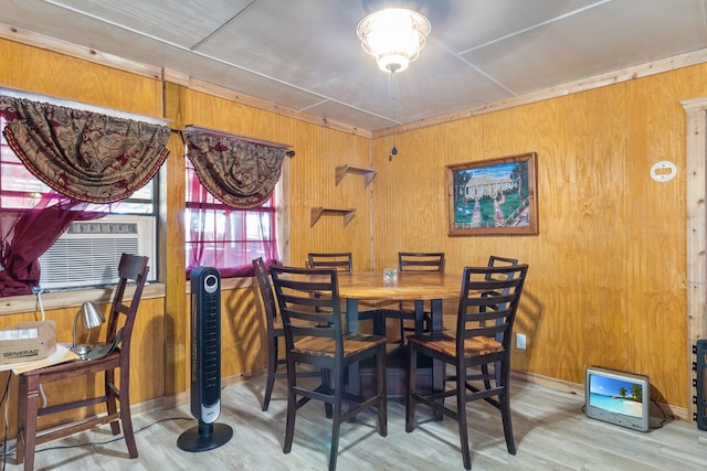 dining area featuring hardwood / wood-style floors, wood walls, and cooling unit